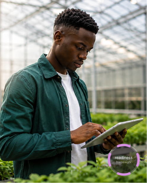 Founder reviewing operations on a tablet in a greenhouse